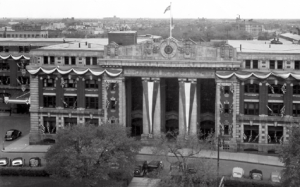 a black and white aerial photo of 181 Higgins pillar doors, 19th century, The pillars have banners over them, and the building is decorated.