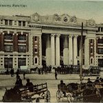 a colored photo of 181 Higgins, with many horse wagons on the road. 19th century.